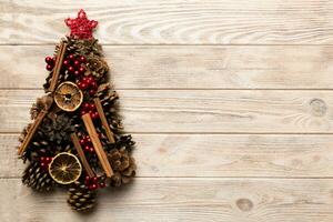 Christmas tree made from natural cones on colored background, view from above. New Year minimal concept with copy space photo