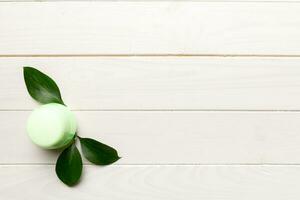 Organic cosmetic products with green leaves on wooden background. Copy space, flat lay photo