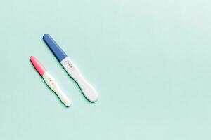 Colored Pregnancy test on colored background, top view with copy space photo