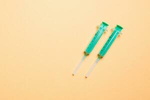 Top view of syringes in a row for medical injection on colorful background with copy space. Health and vaccination concept photo