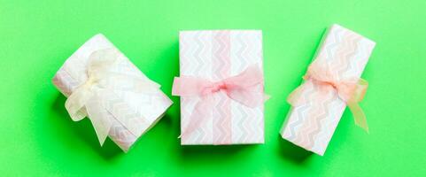 Top view Christmas present box with Colored bow on green background photo