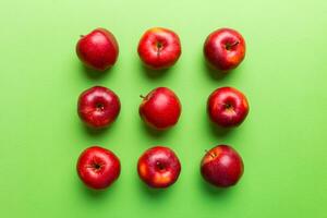 Many red apples on colored background, top view. Autumn pattern with fresh apple above view photo