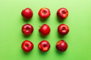 Many red apples on colored background, top view. Autumn pattern with fresh apple above view photo