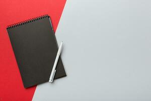 school notebook on a colored background, spiral black notepad on a table Top view photo