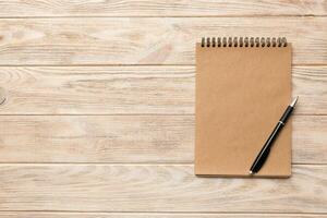 school brown notebook on a colored background, spiral craft notepad on a table Top view photo