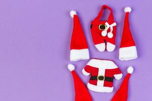 Top view of red Santa hats and clothes on colorful background. Merry Christmas concept with copy space photo