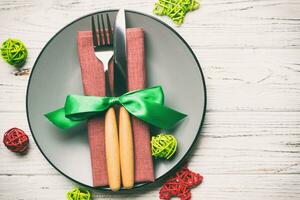 Holiday composition of Christmas dinner on wooden background. Top view of plate, utensil and festive decorations. New Year Advent concept with copy space photo