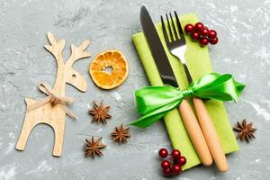 New year set of fork and knife on napkin. Top view of christmas decorations and reindeer on cement background. Close up of holiday family dinner concept photo