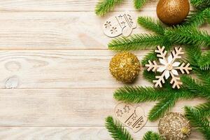 Set of festive balls, fir tree and Christmas decorations on wooden background. Top view of New Year ornament concept with copy space photo