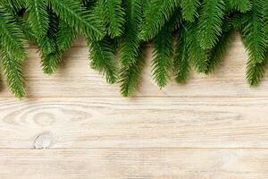 Top view of fir tree branches on wooden background. New Year holiday concept with copy space photo