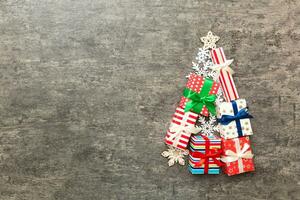 Christmas tree made of beautifuly wrapped presents on colored background, view from above. New Year gift box minimal concept with copy space photo