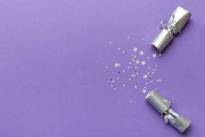 Christmas crackers with shiny confetti on color background, top view, copy space photo