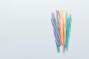 Heap of colorful plastic drinking straws on Colored background, flat lay. Copy Space for text photo