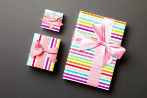 Top view Christmas present box with pink bow on black background photo