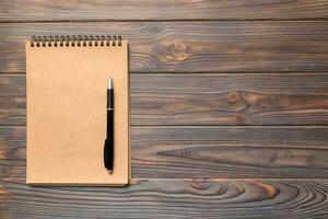 school brown notebook on a colored background, spiral craft notepad on a table Top view photo