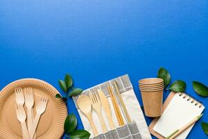 set of empty reusable disposable eco-friendly plates, cups, utensils on light white colored table background. top view. Biodegradable craft dishes. Recycling concept. Close-up photo