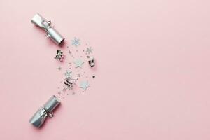 Christmas crackers with shiny confetti on color background, top view, copy space photo