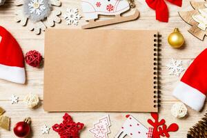 Top view of notebook on wooden background made of Christmas decorations. New Year concept photo