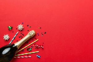 bottle of champagne with glasses and colorful confetti on colored background. top view flay lay photo