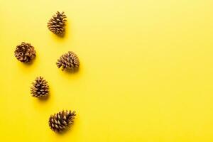 Christmas pine cones on colored paper border composition. Christmas, New Year, winter concept. Flat lay, top view, copy space photo