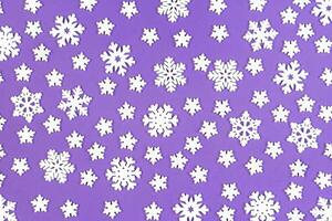 Top view of white snowflakes on colorful background. Winter weather concept with copy space. Merry Christmas concept photo