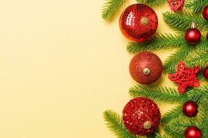 Christmas composition made of fir tree, balls and different decorations on colorful background. Top view of New Year Advent concept with empty space for your design photo