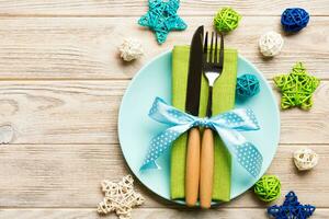 Holiday composition of Christmas dinner on wooden background. Top view of plate, utensil and festive decorations. New Year Advent concept with copy space photo