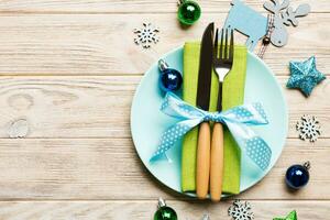 Holiday composition of Christmas dinner on wooden background. Top view of plate, utensil and festive decorations. New Year Advent concept with copy space photo