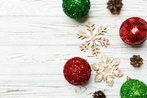 Top view of festive winter composition on wooden background with empty space for your design. Christmas baubles and decorations. New Year concept photo