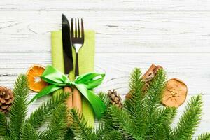 Top view of utensils on festive napkin on wooden background. Christmas decorations with dried fruits and cinnamon. New year dinner concept with copy space photo