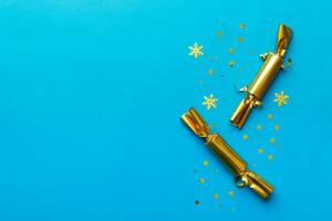 Christmas crackers with shiny confetti on color background, top view, copy space photo