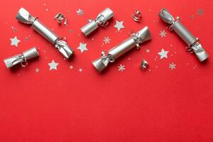 Christmas crackers with shiny confetti on color background, top view, copy space photo
