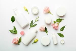 Composition with cosmetic products and beautiful roses on white background. Flat lay photo