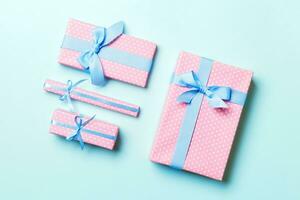 Gift box with blue bow for Christmas or New Year day on blue background, top view photo