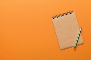 school brown notebook on a colored background, spiral craft notepad on a table Top view photo