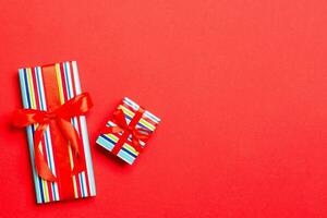 Top view Christmas present box with red bow on red background photo