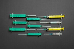 Top view of different syringes at black background. Medical injection concept with copy space photo