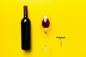 Flat lay composition with corkscrew, bottle of wine and elegant glass on colored table. Flat lay, top view wth copy space photo