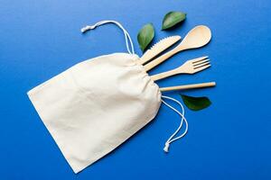 Eco friendly reusable recyclable white eco bag with kitchenware on Colored background. Concept zero waste photo