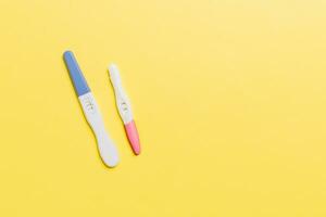 Colored Pregnancy test on colored background, top view with copy space photo