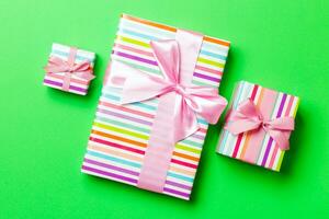 Top view Christmas present box with pink bow on green background photo