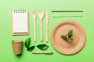 set of empty reusable disposable eco-friendly plates, cups, utensils on light white colored table background. top view. Biodegradable craft dishes. Recycling concept. Close-up photo