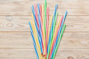 many multi-colored plastic tubes for cocktail on Colored background, top view photo