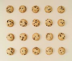 Creative chocolate cookies pattern on pastel cream background. Minimal food concept. Yummy chocolate biscuits idea. Flat lay cookies composition. Top of view. photo