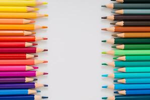 Creative layout made of colored pencils on white background. Minimal back to school concept. Trendy school idea. Colored pencils aesthetic. Flat lay. Copy space for text. photo