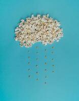 Creative design of cloud made of popcorn on light blue background. Minimal concept. photo