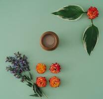 Trendy summer minimal arrangement made of flowers, green leaves and cup of coffee. Nature composition idea. Coffee flat lay concept. Flowers aesthetic. photo