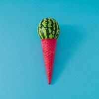 Ice cream made of pink waffle ice cream cone and scoop of watermelon fruit on light blue background. Summer ice cream composition. Minimal food concept. Creative yummy summer watermelon flat lay idea. photo