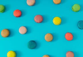 Creative colorful pattern made of various macarons on bright blue background. Minimal sweet food concept. Trendy macaron cookies pattern background. Yummy flat lay idea. photo