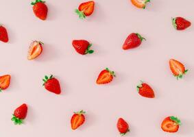 Trendy fruit pattern made of fresh and healthy strawberries on light pastel pink background. Creative minimal strawberry pattern composition. Nature food concept. Fancy pink background flat lay. photo
